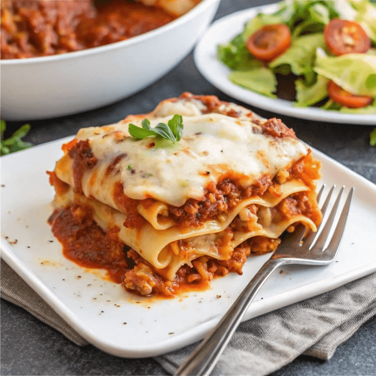 Lasagna in preparation with sauce spread first, exploring the correct order of ingredients.