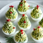 Christmas tree deviled eggs arranged on a white holiday platter