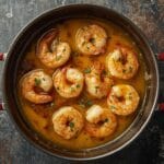 Garlic butter shrimp cooked in a skillet with lemon and parsley.