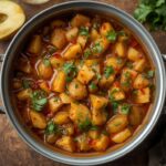 Spicy green apple pickle in a glass jar with visible mustard seeds and Indian spices