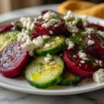 Beet Salad with Feta Cucumbers and Dill on a wide white plate showing vibrant ruby red beets crisp cucumber and white feta crumble with fresh dill