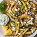 Homemade Greek fries feta parsley red onion plate