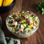 Street corn cucumber chicken salad with creamy smoked paprika dressing and feta in a white bowl