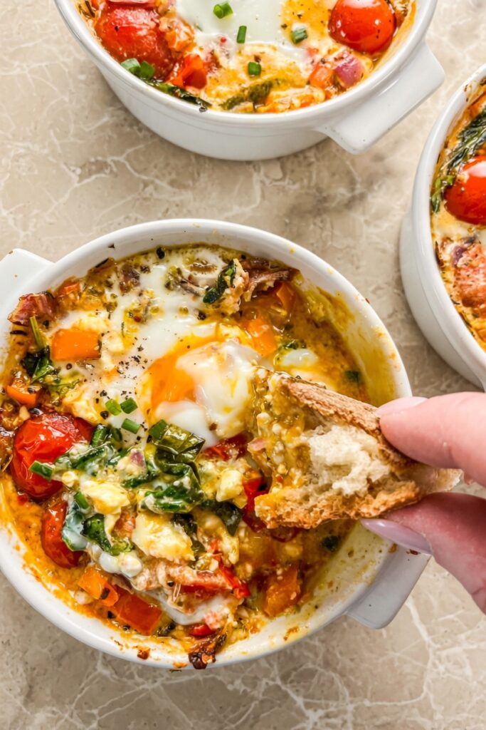 Baked Feta Eggs Pinterest vertical image showing white ramekin with golden eggs roasted tomatoes and clean text overlay on white background