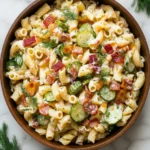 Crispy golden bacon cooking in a skillet for dill pickle bacon pasta salad