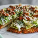Chicken crust Caesar salad pizza sliced on board