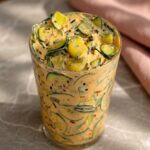 Close-up of Viral Creamy Asian Cucumber Salad showing creamy spicy dressing over crisp cucumber slices edamame and golden tofu in a wide bowl