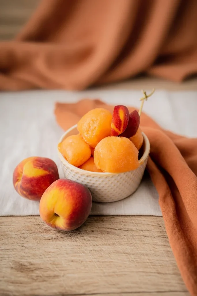 Peach sorbet scoop smooth texture closeup peaches